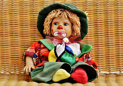 doll wearing green clothes on brown woven surface