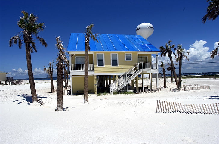 yellow and blue wooden house near sea during daytime