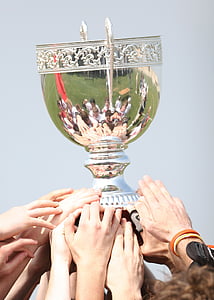 people holding silver trophy