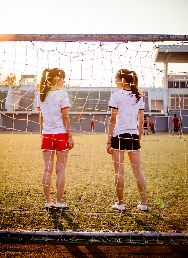 two women standing in front of soccer goal