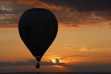 person riding hot air balloon during golden hour