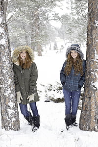 two women wearing black and blue parka jackets