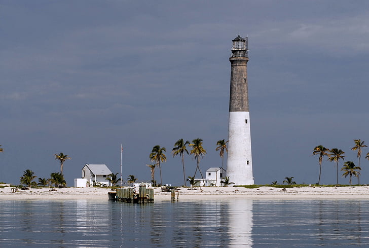 landscape photo of beach with white and gray lighthouse