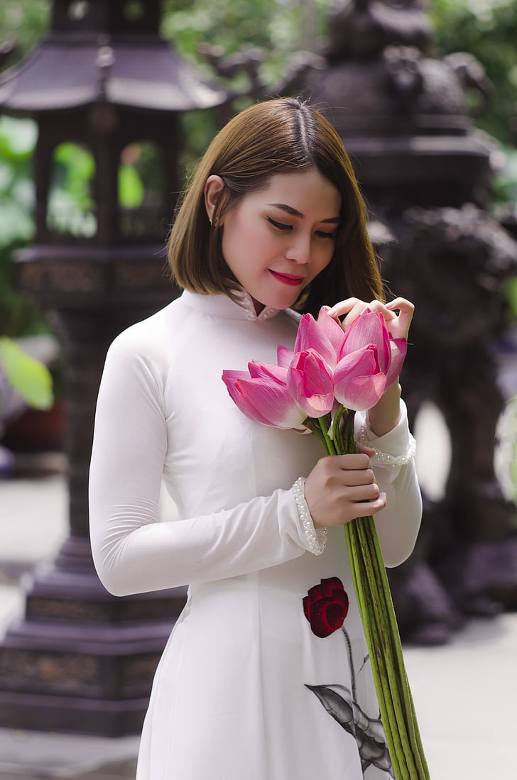 woman holding pink petaled flowers