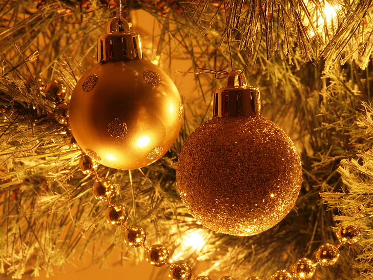two gold baubles hanging on Christmas tree