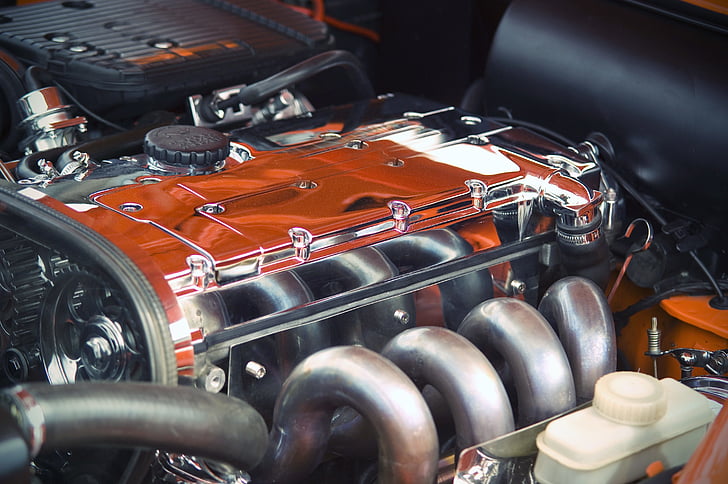 close up photography of orange and gray vehicle engine