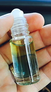 person holding clear glass mini roll-on bottle
