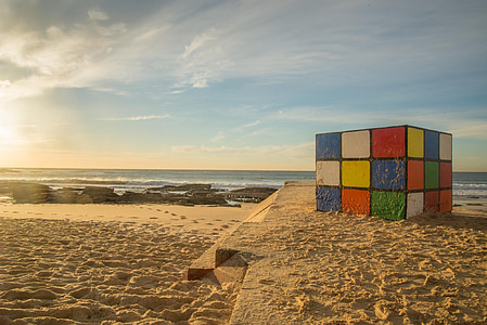 selective focus photography of 3x3 Rubik's cube on beach sand