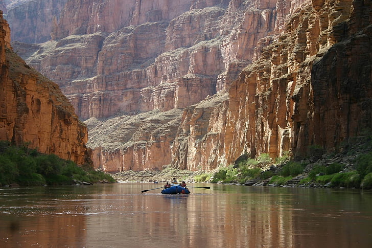 person riding on boat between mountains