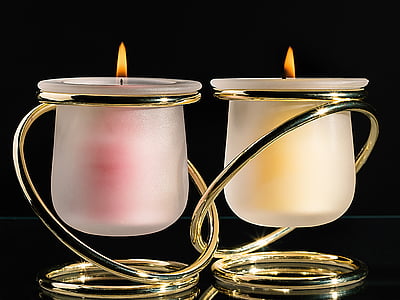 two lighted brass-colored handle candle holder
