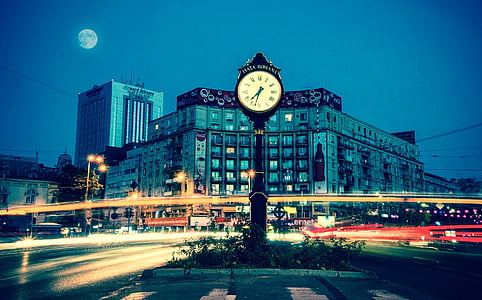 photo of black and white clock near concrete building