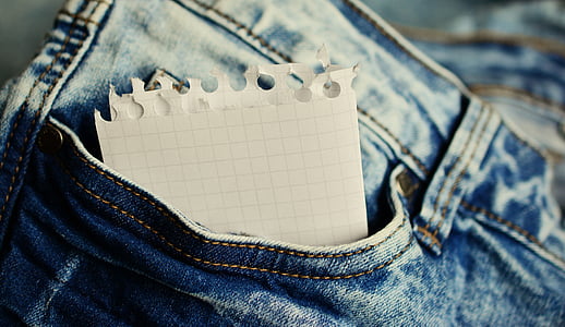 shallow focus of white paper in jeans