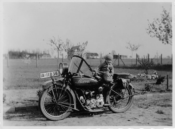 grayscale photo of boy riding motorcycle