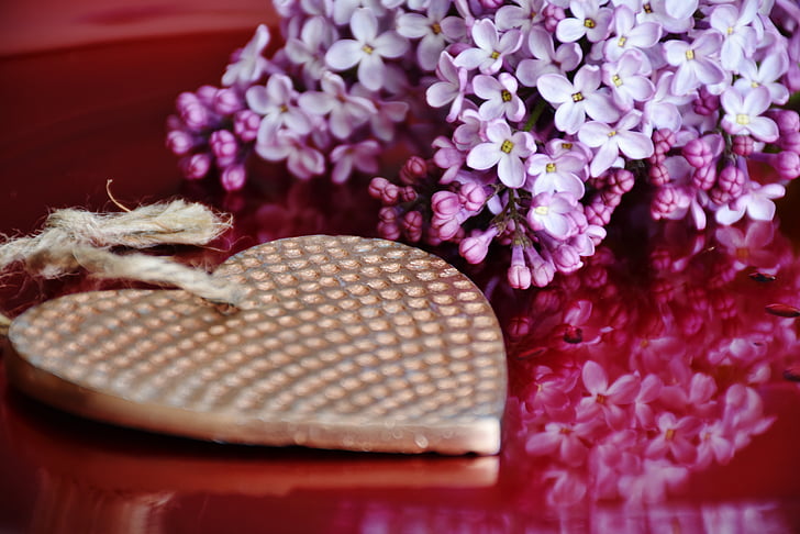 purple flower centerpiece near gold-colored heart pendant
