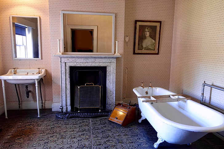 white clawfoot bathtub near fireplace