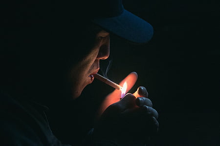 close-up photography of person lighting cigarette