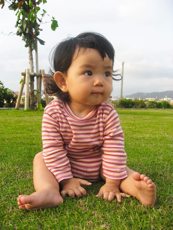 toddler's sitting on grass
