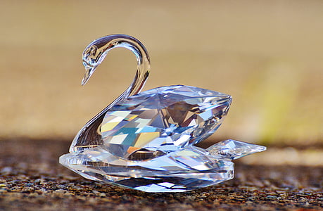 shallow focus photo of cut-glass swan paperweights