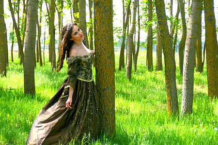 woman wearing brown floral dress standing beside tree