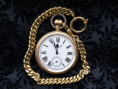 white pocket watch with gold-colored chain