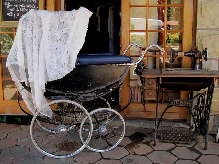photo of pram stroller beside threadle sewing machine