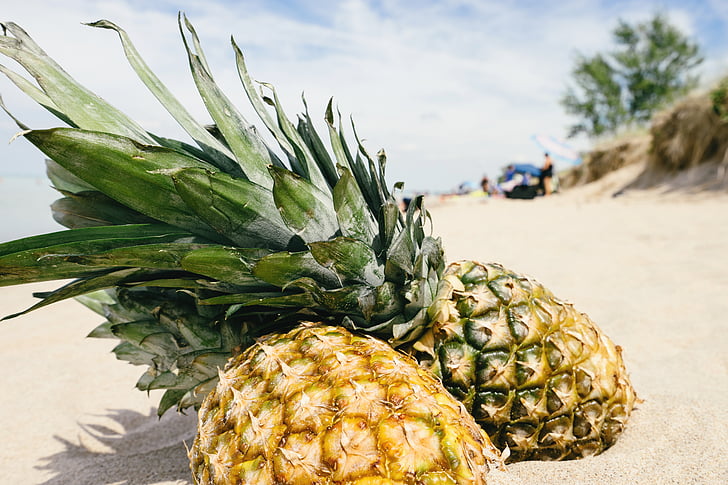 two pineapple on the sands during daytime