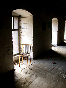 empty brown wooden chair beside glass window inside the building