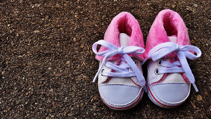 children's pair of pink-and-white shoes on ground