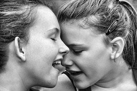 grayscale photo of two women face to face