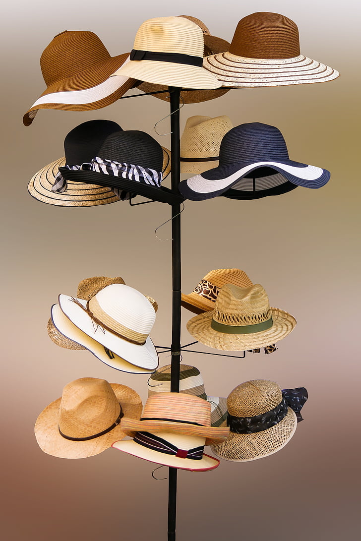 assorted hats hanging on tower rack