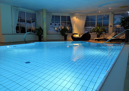 indoor below-ground swimming pool with blue lights during nighttime