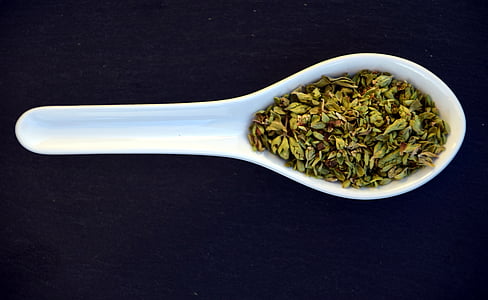 green spice on white cermic spoon