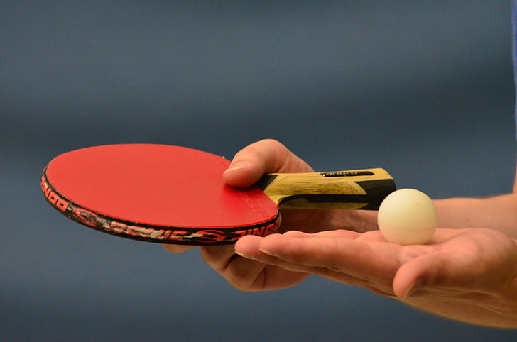tilt-shift photography of ping pong paddle with ball