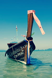 brown and black boat on the body of water