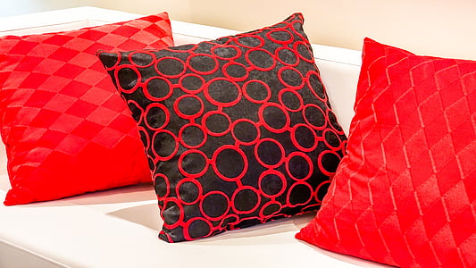 three red throw pillows on white sofa