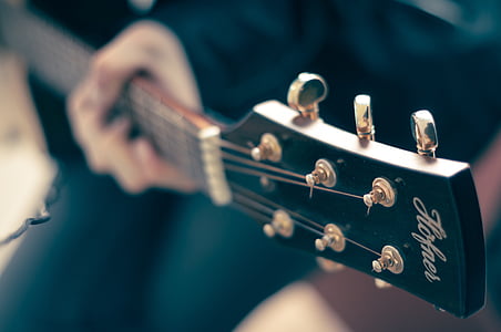selective focus photography of person playing guitar