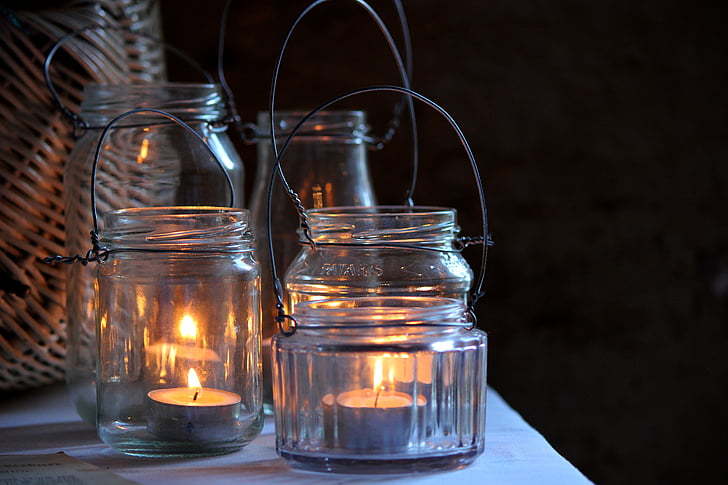 four jars with lighted tealights