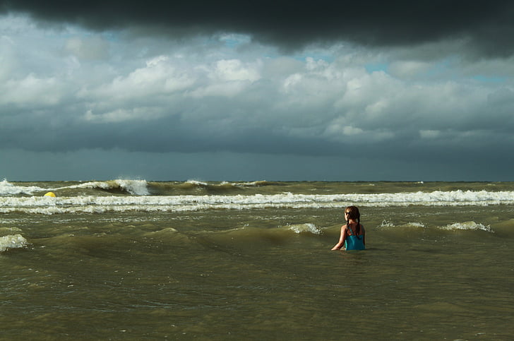 girl wearing cyan swimsuit on water