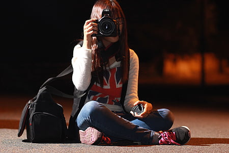 photo of woman holding DSLR camera