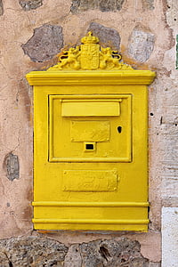 rectangular yellow metal box on brown concrete wall