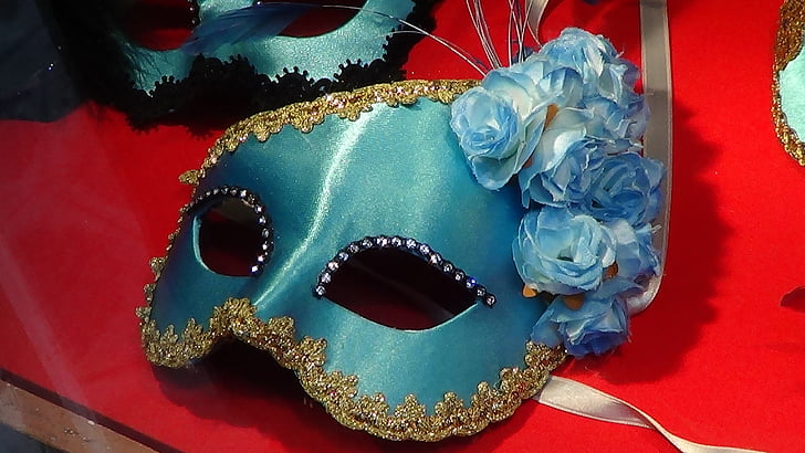 blue masquerade mask on top of red table