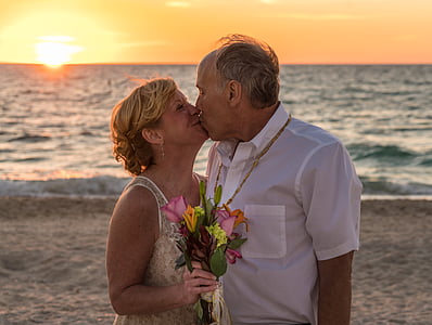 man and woman kissing near ocean