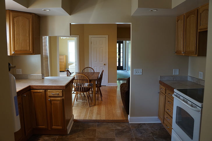 white induction range oven beside brown wooden kitchen cupboard