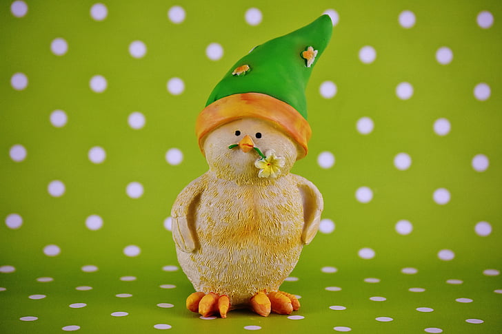duckling biting yellow petaled flower figurine on green and white polka-dot surface