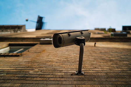 selective focus photography of bullet security camera on brick wall