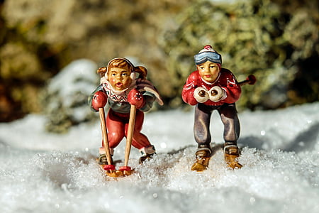 two woman snow skiing on white textile figurines