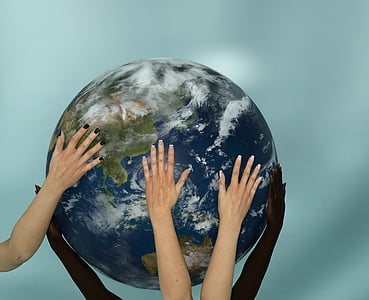 human hands holding earth scale model