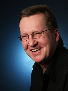 man wearing black framed eyeglasses while smiling