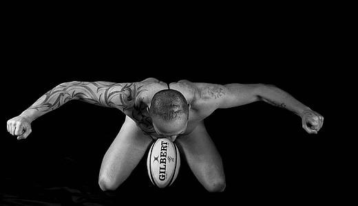 photography of man topless with Gilbert football