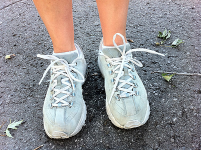 person's feet wearing blue-and-white running shoes